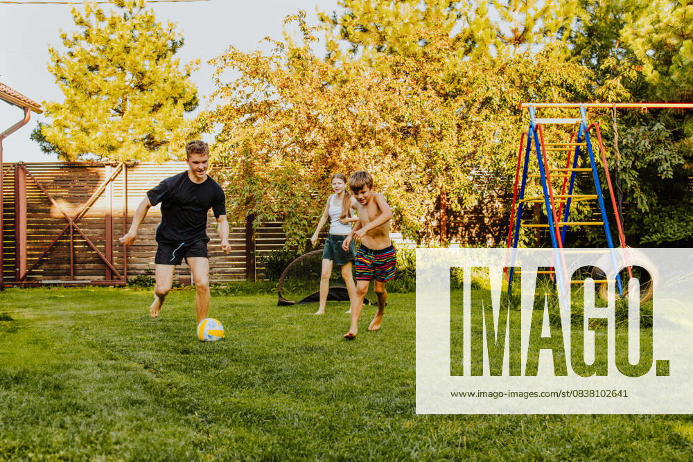 Teens and kids playing football together in a sunny back yard model released, Symbolfoto property released, MDOF03159