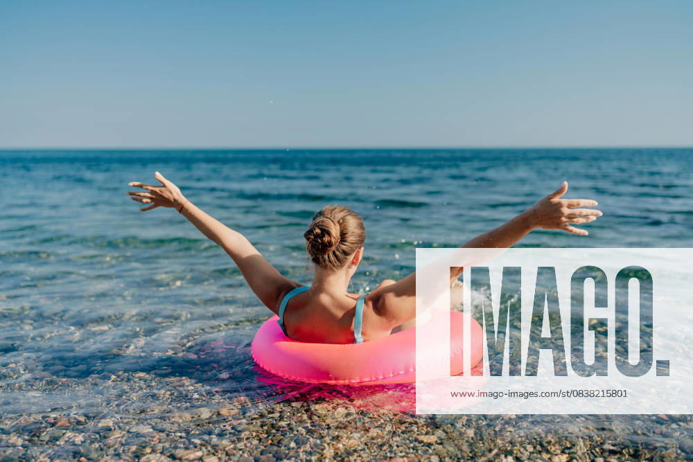 A woman is floating on a pink inflatable raft in the ocean A woman is floating on a pink inflatable raft in the ocean. She is smiling and she is enjoying herself, model released, , property released, , 60823270.jpg RECORD DATE NOT STATED