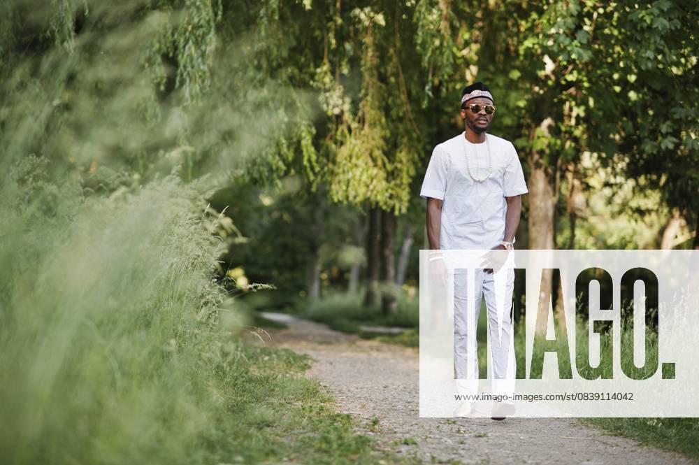 Porträt eines stilvollen und reichen schwarzafrikanischen Amerikaners auf weißer Kleidung, Sonnenbrille und Hut Portrait of stylish and rich black african american man on white clothes, sunglasses and hat