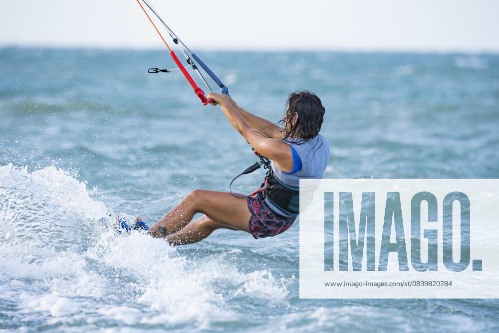 MR_ID31715_22956_LauraGiralgo.jpg A woman enjoys kitesurfing in the vibrant blue waters of Mayapo, La Guajira, Colombia. The wind and waves create the perfect backdrop for an exhilarating water sport experience Model Released VictorCuenca_ID31715_1078690_009