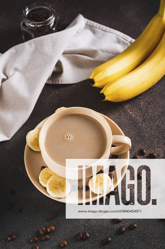 IMAGO Creative, Food, Trend, Iced Coffee Gemischter gefrorener Bananenkaffee in einer Tasse auf dem Tisch, vertikale Ansicht Blended frozen banana coffee in a cup on the table vertical view