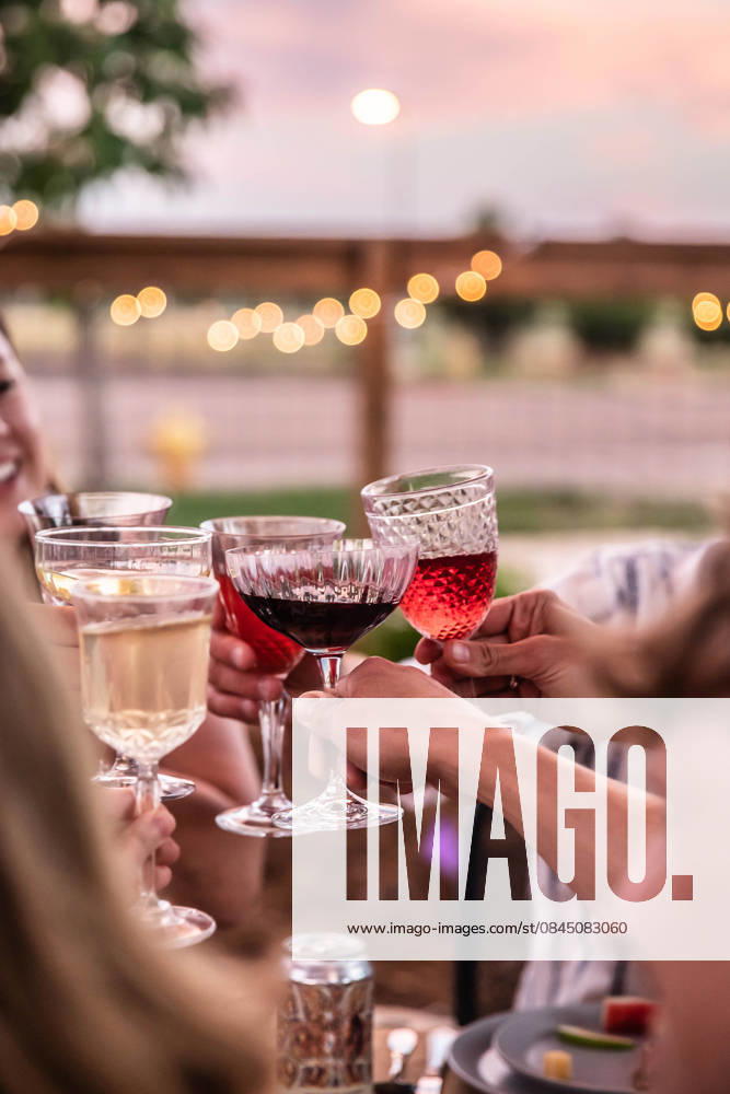 IMAGO Creative, Lifestyle, Feste im Garten #2 Friends raising glasses at dusk toasting at outdoor celebration dinner Fort Collins, Colorado, United States CR_YVOQ260106-1920793-01
