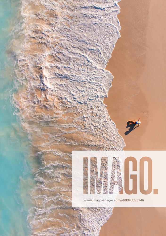 Aerial view of woman on sandy beach as ocean waves roll in. Grace Bay, Caicos Islands, Turks and Caicos Islands CR_DOHO260224B-1973403-01 ,model released, Symbolfoto