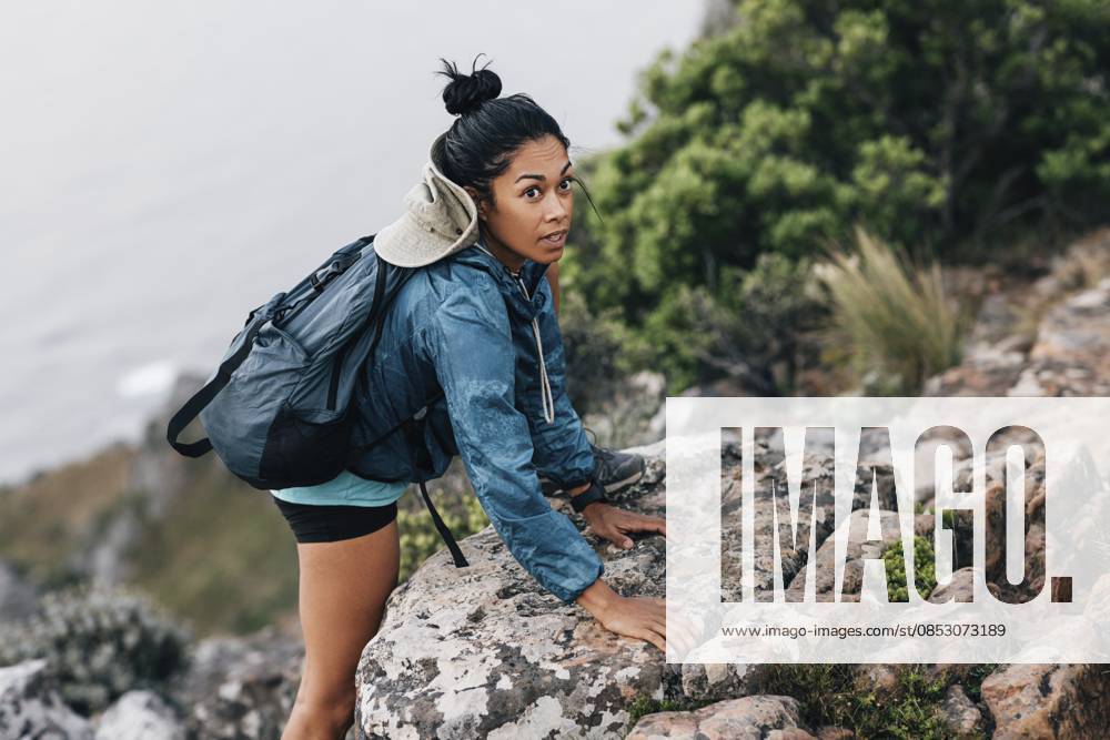 Junge Frau auf einer Wanderung. Wanderin klettert hinauf Young woman on a hike. Female hiker climbing up