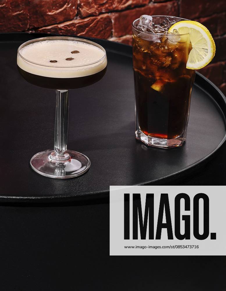 IMAGO Creative, Food, Trend, Iced Coffee Food, Zwei Cocktails werden auf einem schwarzen runden Tisch präsentiert. Eines ist ein cremefarbenes Getränk, garniert mit Kaffeebohnen, und das andere ist ein dunkles Eisgetränk mit einer Zitronenscheibe Food, Two cocktails are presented on a black round table. One is a smooth cream-colored drink garnished with coffee beans, and the other is a dark iced beverage with a lemon slice