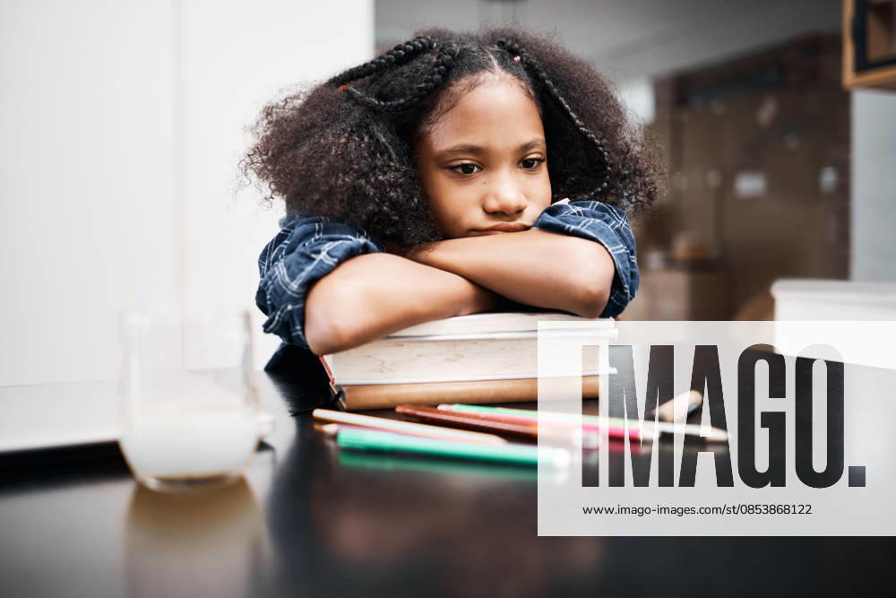 Shot of a young girl looking unhappy while doing a school assignment at home. (License=RF) ,model released, Symbolfoto