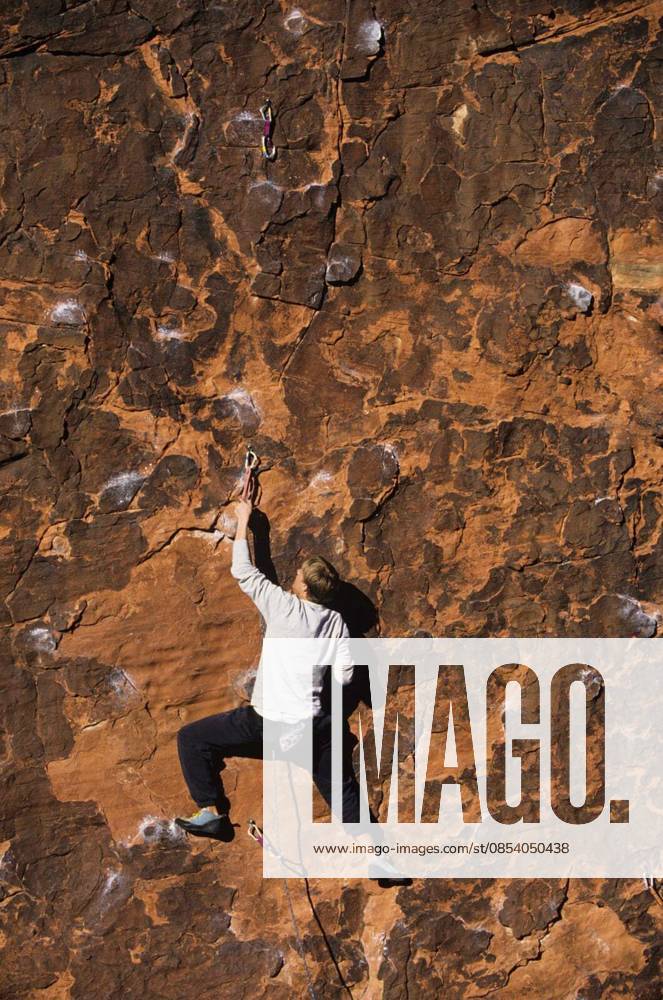 Rock Climber Climbing Up A Cliff - Rear view of rock climber climbing up a cliff model released Symbolfoto