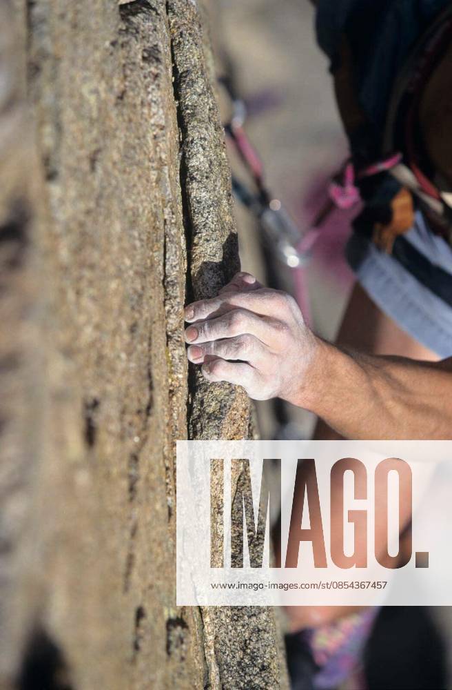 Cropped image of rock climber holding on to cliff model released Symbolfoto