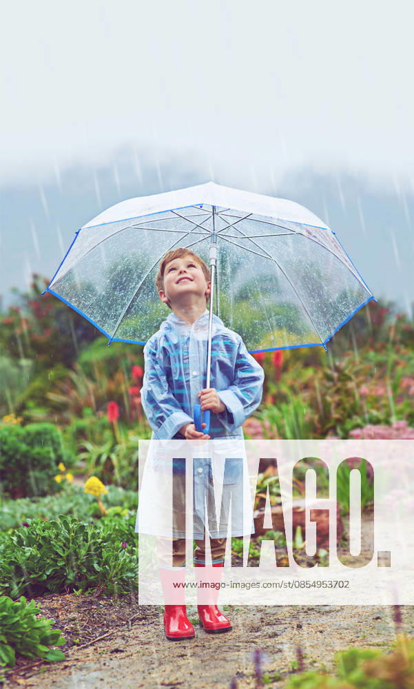 My garden loves the rain. Full length shot of a young boy standing outside in the rain (License=RF) ,model released, Symbolfoto