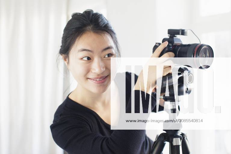 Smiling young woman photographing with camera