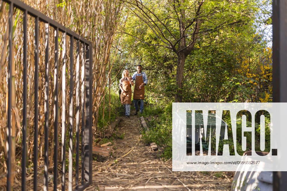 Gardeners wearing aprons walking and talking in lush garden model released, Symbolfoto, JCCMF14933