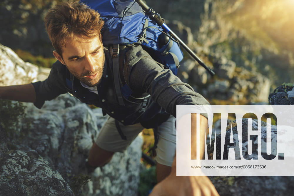 Mountains were made to get over. a young man hiking up a mountain (License=RF) ,model released, Symbolfoto