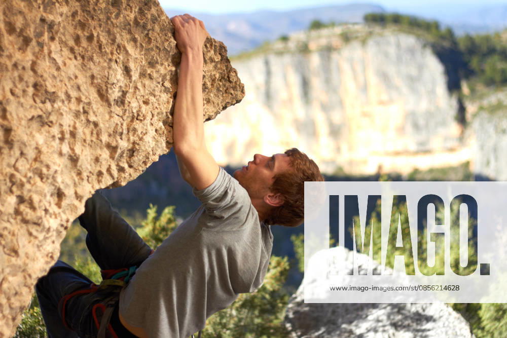 Rock, climbing and man with nature, exercise and fresh air with endurance, mountains and freedom with workout, sky and wellness. Person, athlete or guy with fitness, travel or environment with health. (License=RF) ,model released, Symbolfoto