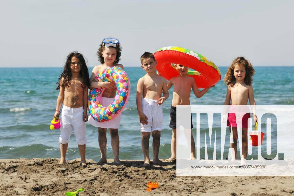 Happy child group have fun on beach while playing with toys running jumping model released Symbolfoto