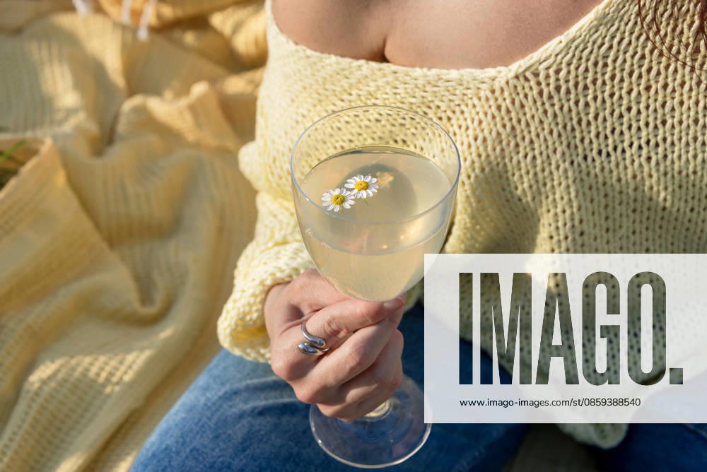 Woman holding a glass of floral lemonade or limoncello while relaxing R_YEPI260616-2055192-01 ,model released, Symbolfoto