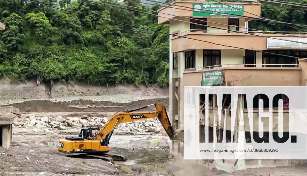 Nuwakot Nepal , Aug 30 (ANI): An excavator clears debris near a damaged multi-storey building after a devastating flood tore through the area at Trishuli, in Nuwakot on Sunday. (ANI Video Grab) Nuwakot Nepal
