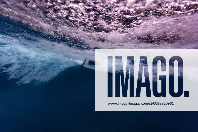 Maledives, Under water view of wave, surfer sitting on surfboard, underwater shot KNTF02302