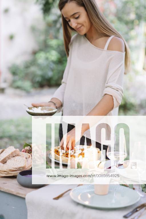 Woman preparing a romantic candelight meal outdoors model released Symbolfoto ALBF00709