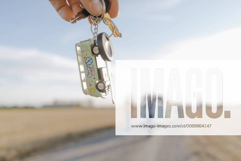 Hand holding camper van key in rural landscape model released Symbolfoto GUSF01390