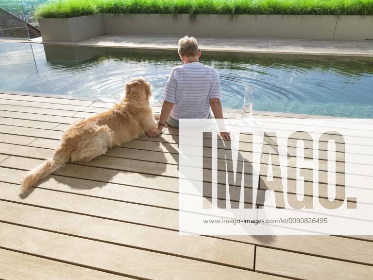 Senior woman sitting with dog at the poolside model released Symbolfoto property released LAF02209
