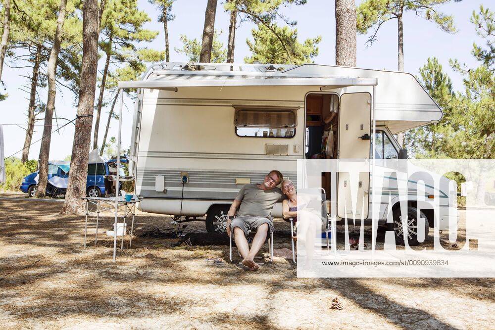 France, Gironde, happy couple sitting in front of camper on camping ground model released Symbolfoto property released JATF01135