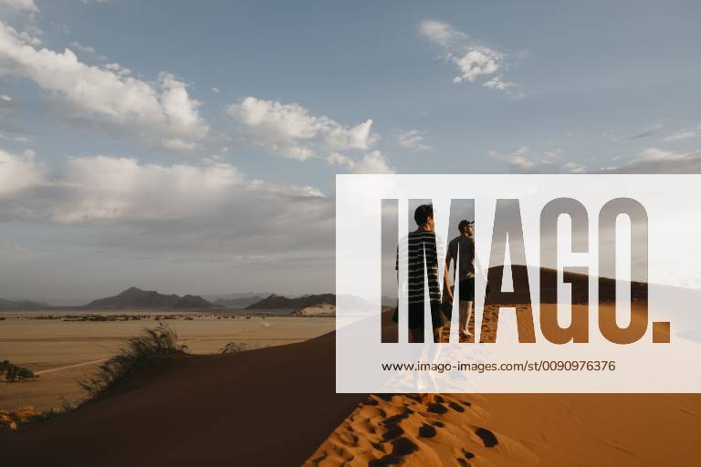 IMAGO Creative: Sommer, Abendspaziergang Namibia, Namib desert, Namib-Naukluft National Park, Sossusvlei, two men walking on Elim Dune at sunset model released Symbolfoto LHPF00254