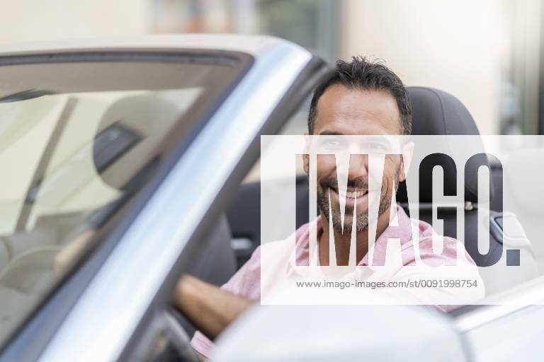 Portrait of smiling man driving convertible model released Symbolfoto DIGF06985