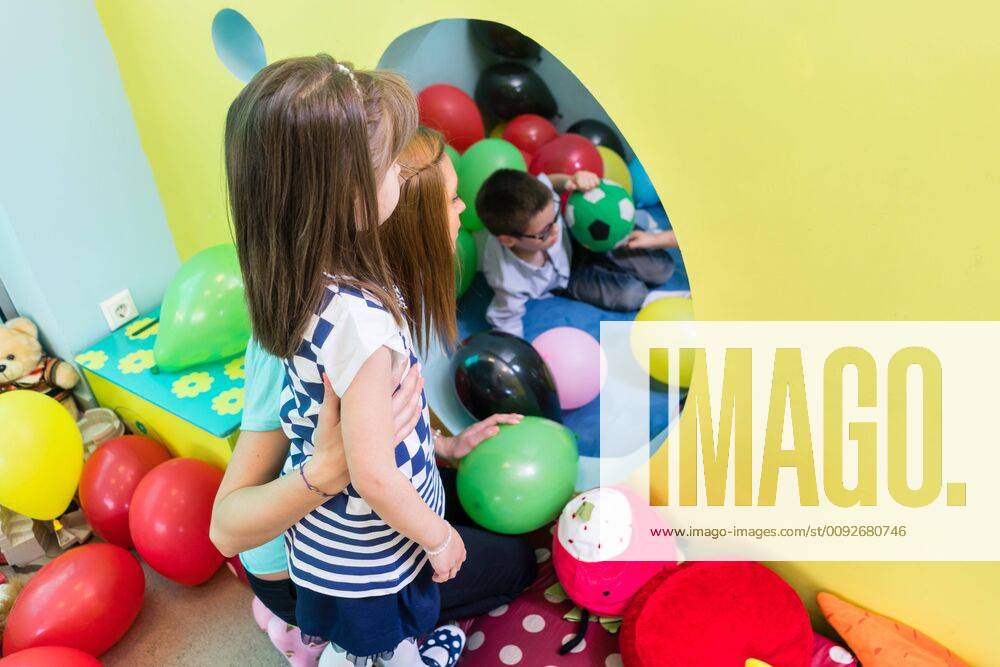 IMAGO Creative: Gesellschaft, Integration Caring teacher guiding a shy pre-school girl during playtime ,model released, Symbolfoto