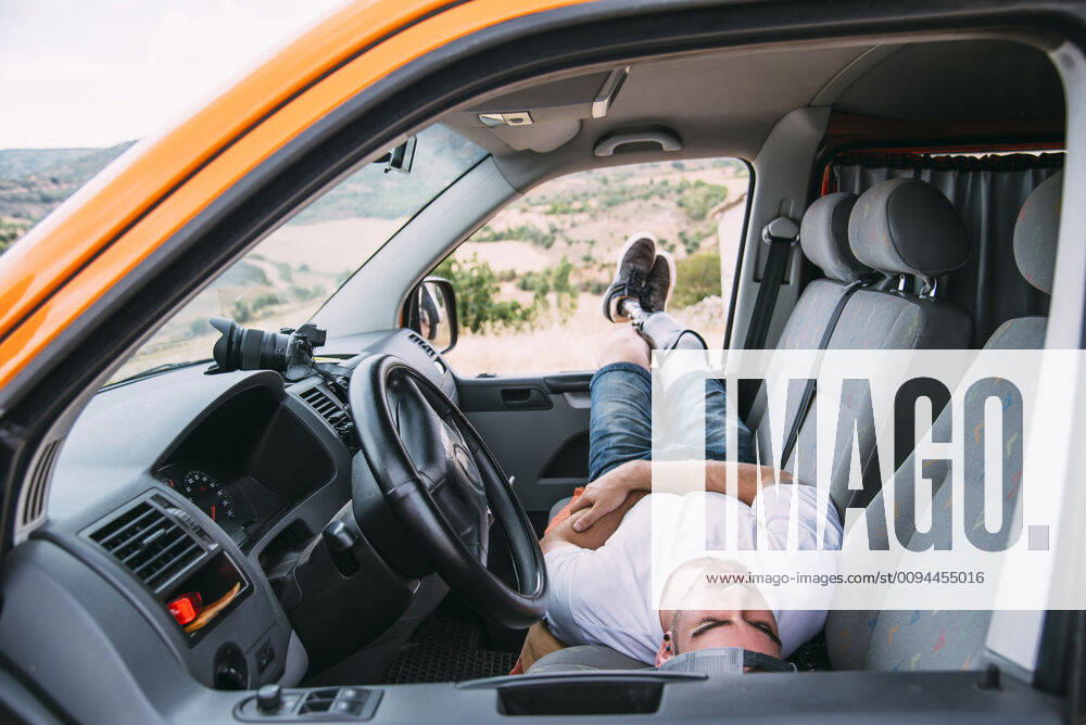 Young man with leg prosthesis resting in camper van model released Symbolfoto CJMF00024