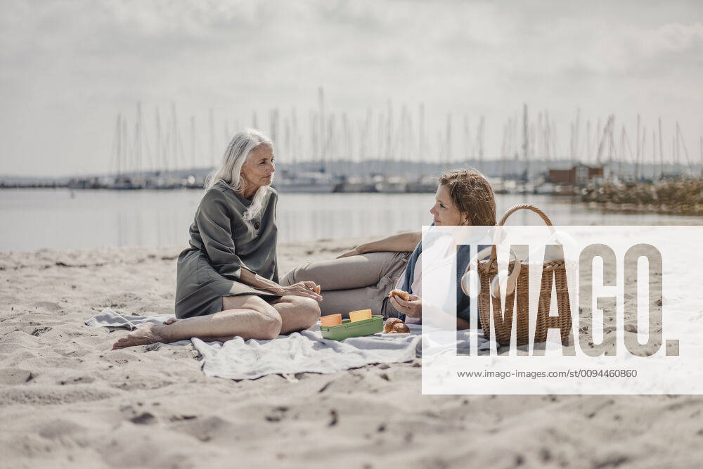 Mother and daughter having a picnic on the beach model released Symbolfoto JOSF03696
