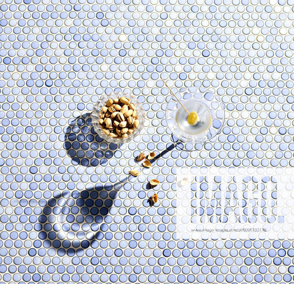 Directly above shot of pistachios and martini glass on blue patterned background KSWF02072