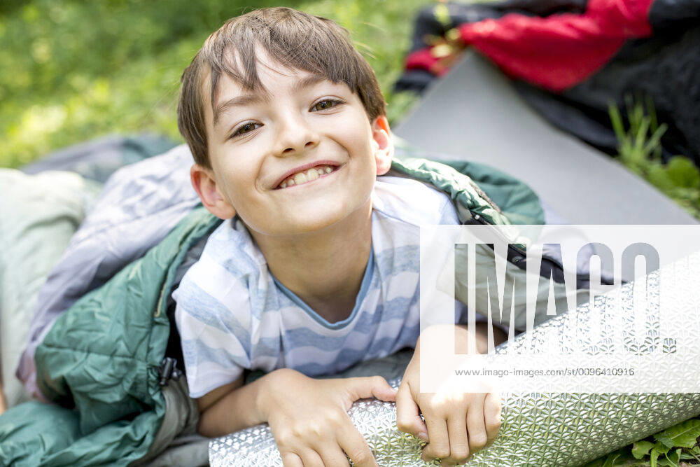Little boy lying on sleeping bag, looking at camera model released Symbolfoto WESTF24489