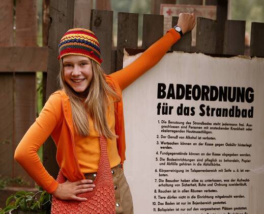 Hauptdarstellerin Lea Eisleb vor einem Schild am Eingang des Flussbades ...