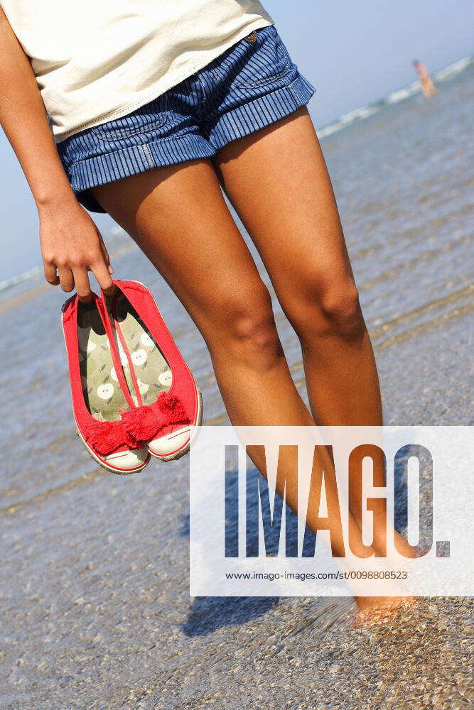 walk-on-beach-woman-walking-on-the-beach-barefeet-holding-her-shoes-y