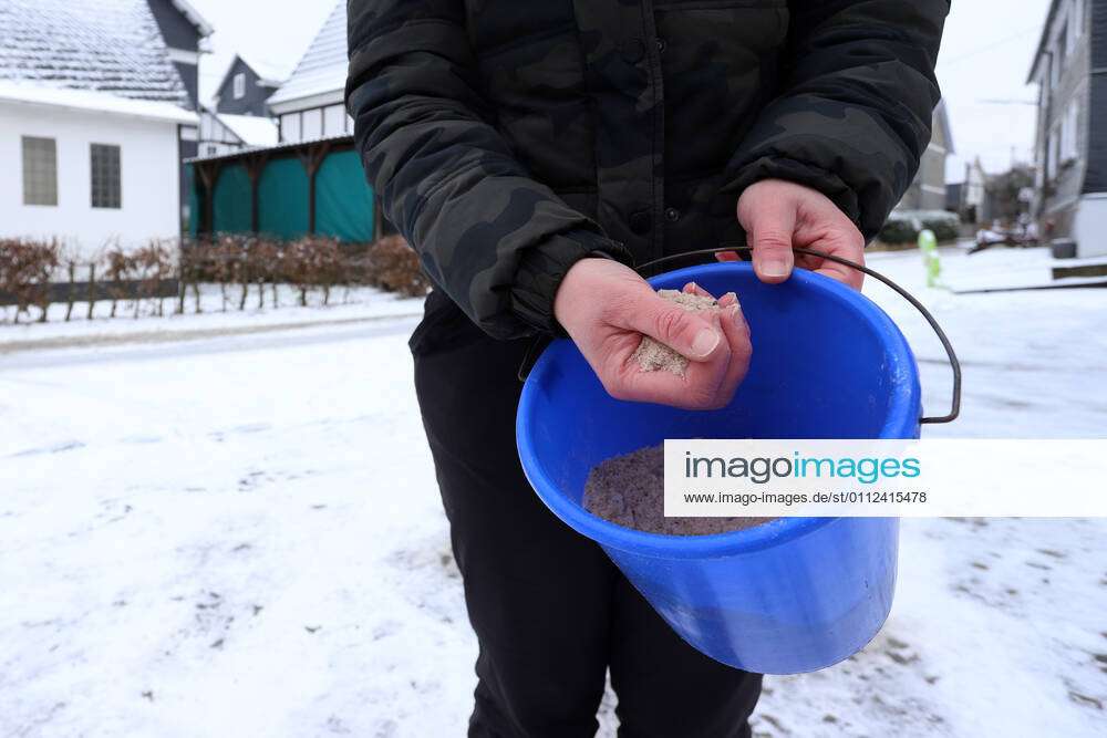 Dauerfrost im Siegerland, eine Frau hat Streusalz in einem Eimer