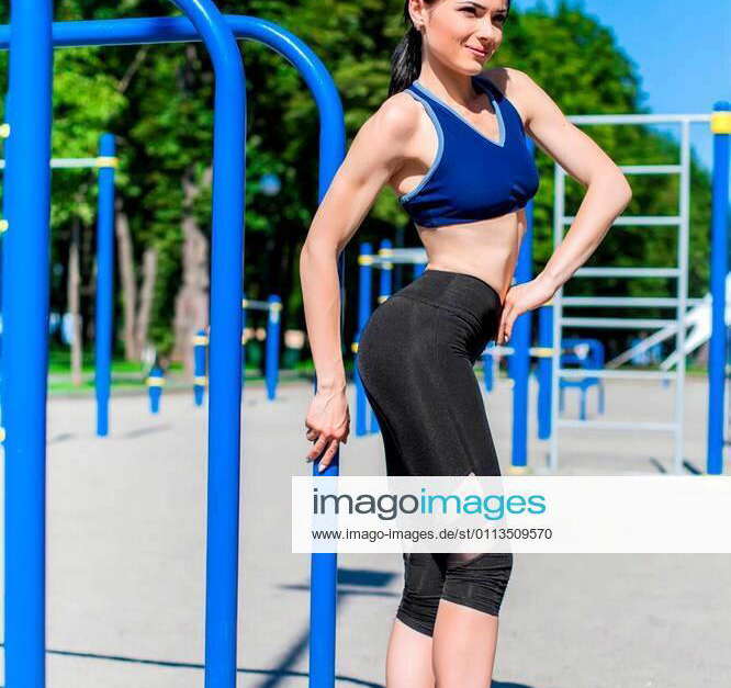 Strong athletic teen in a bright blue sport bra and black leggings