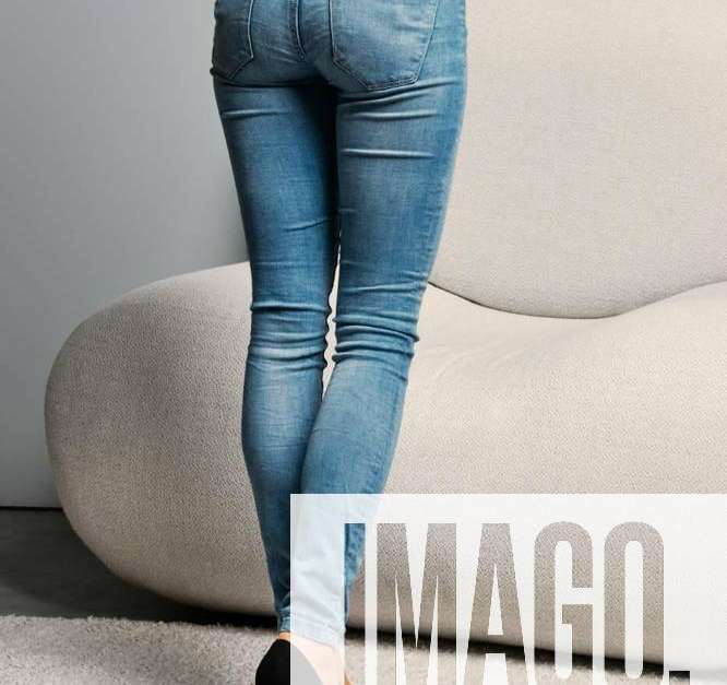 Cropped image of female legs in beige pantyhose and denim jeans