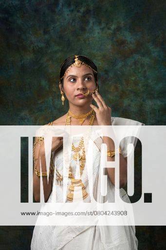 Young Indian woman in traditional attire adorned with gold jewelry ...