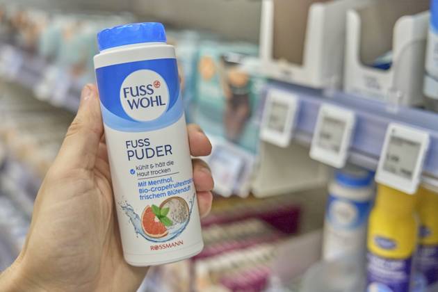 Fußwohl, Fuß Wohl, Fuß wohl, Fusswohl, Fusspuder mit kühlendem Menthol in einer Hand vor einem